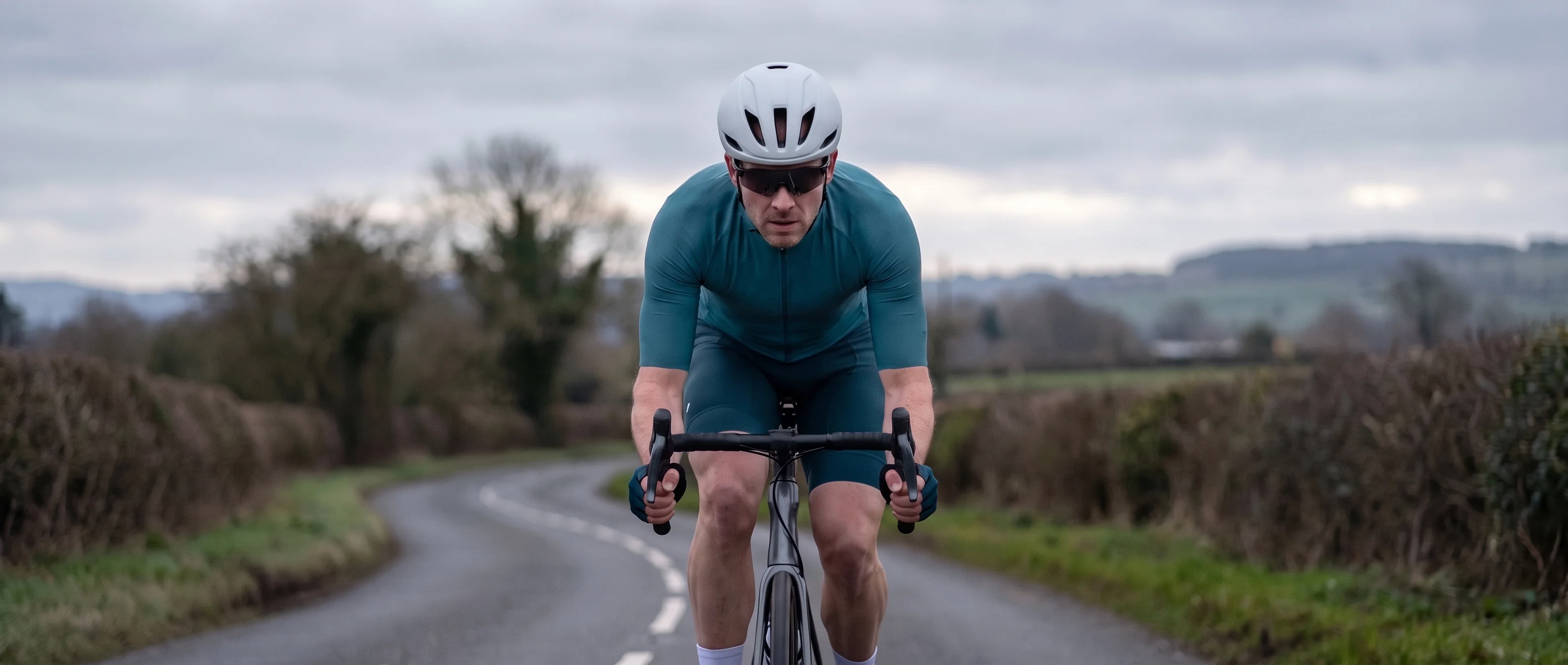 A rider in race position riding head-on toward the camera