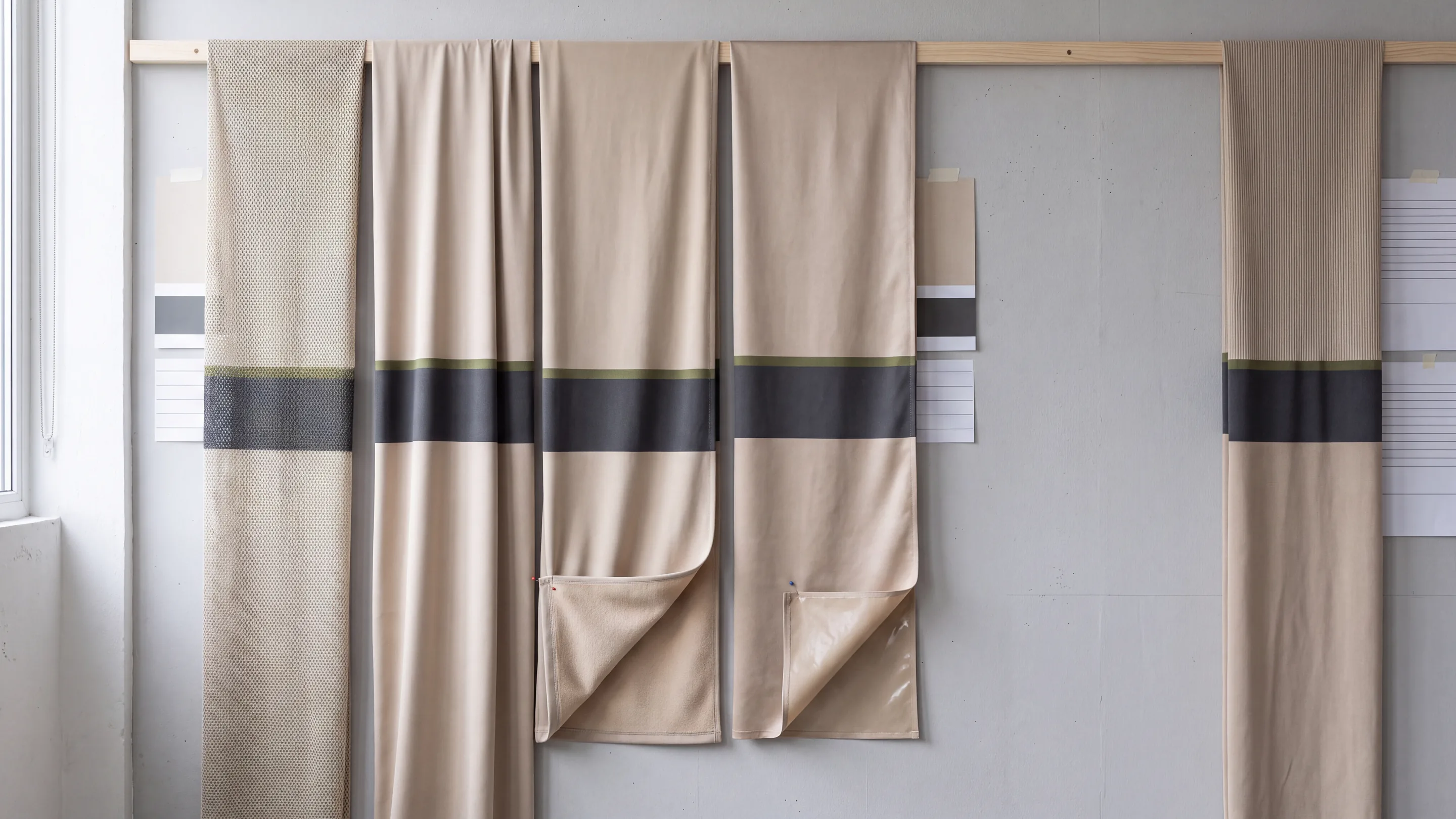 The cut panels of a hot weather jersey laid out by fabric: mesh back, side panels and sleeves beside the main-body front and pocket bag